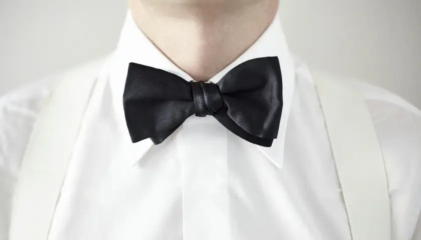 Elegancka biała koszula z czarną muchą i białymi szelkami. Idealny wybór, jeśli zastanawiasz się, jaki kołnierzyk do muchy pasuje najlepiej.