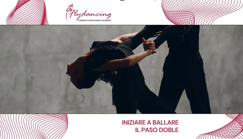 Two dancers in black outfits perform a dramatic Paso Doble pose against a grey backdrop.