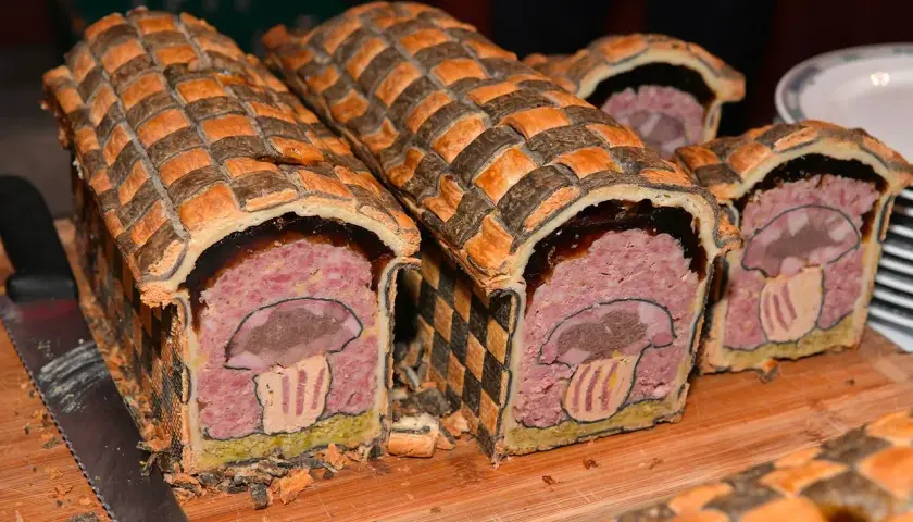 Pâté en croûte d'origine, décoré d'un champignon stylisé. Une œuvre culinaire qui raconte l'histoire de ce plat traditionnel.