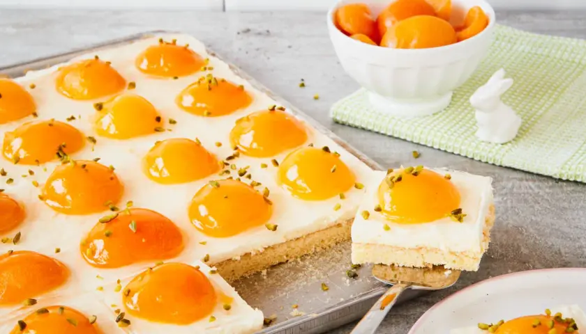 Ciasto z kremem i brzoskwiniami, przypominające jajko sadzone. Posypane pistacjami.
