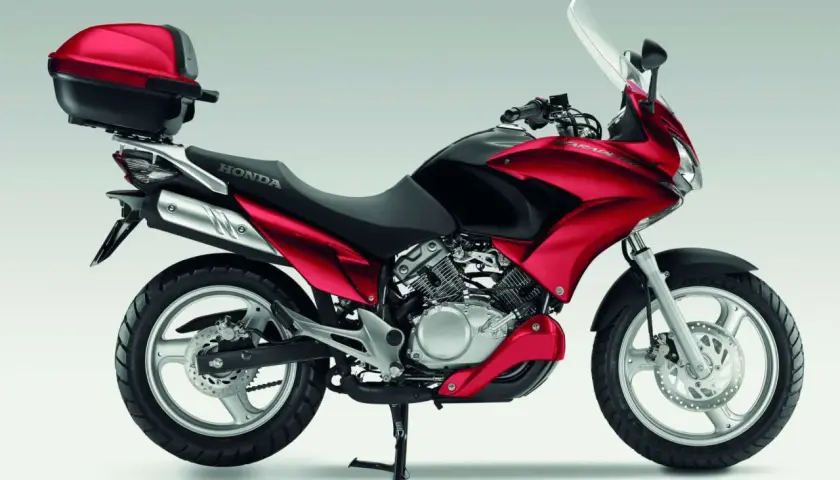 Czerwony motocykl Honda Varadero 125 z kufrem. Poznaj honda varadero 125 dane techniczne i możliwości tego wszechstronnego jednośladu.