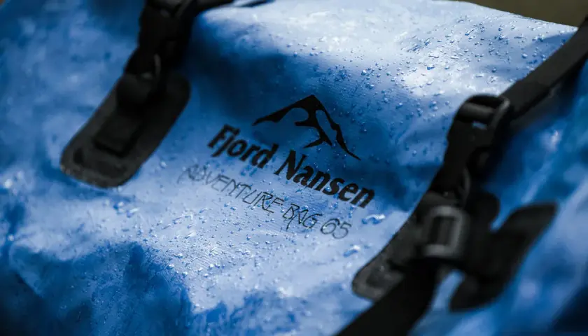 Niebieska torba Fjord Nansen Adventure Bag 65 z kropelkami wody. Waterproof to znaczy, że nic jej nie straszne.