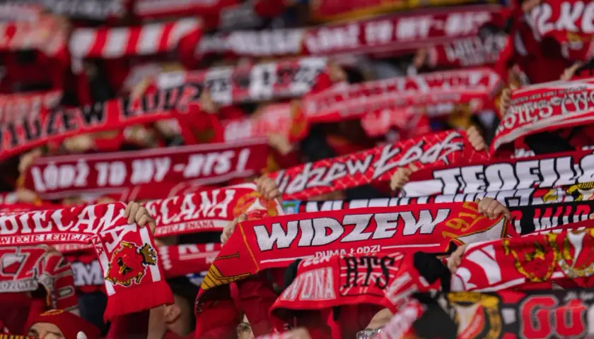 Tłum kibiców Widzewa Łódź z szalikami. Fani świętują, a na szalikach widnieją napisy "Widzew", "Łódź to my" i rok 1910. To symbol ich dumy i wsparcia dla klubu, który zawsze budzi emocje, zwłaszcza podczas ważnych widzew łódź transfery.