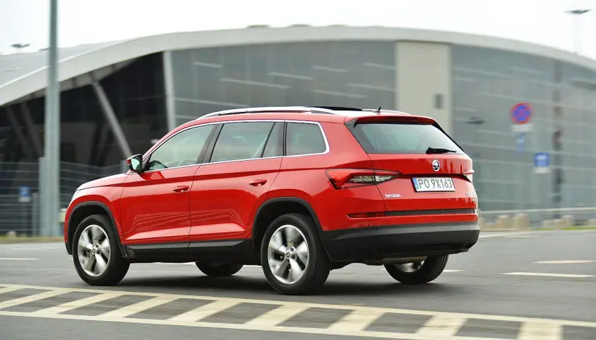 Czerwona Skoda Kodiaq w ruchu. Wiele pozytywnych skoda kodiaq opinie potwierdza jej wszechstronność.