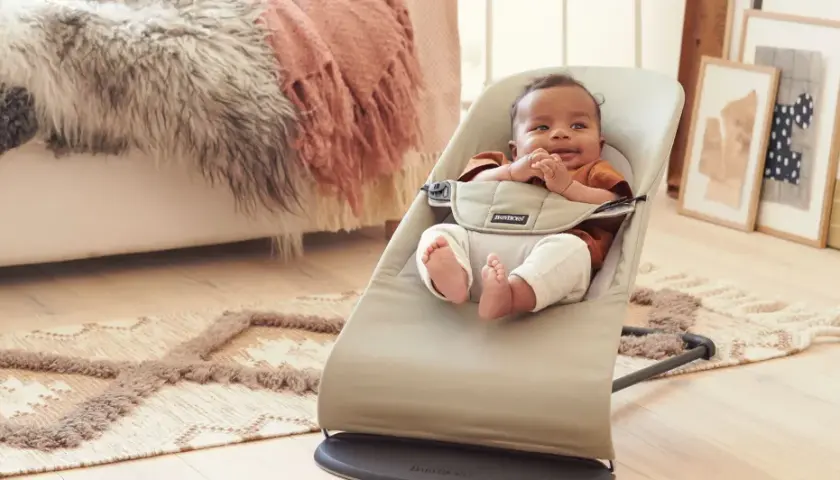 Söt bebis i babysitter. Frågan "när kan man börja använda babysitter" besvaras av att denna lilla redan njuter av den.