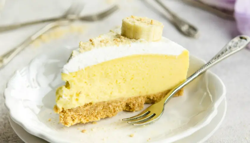 Pyszny sernik bananowy z kremową masą i bananową dekoracją, gotowy do zjedzenia.