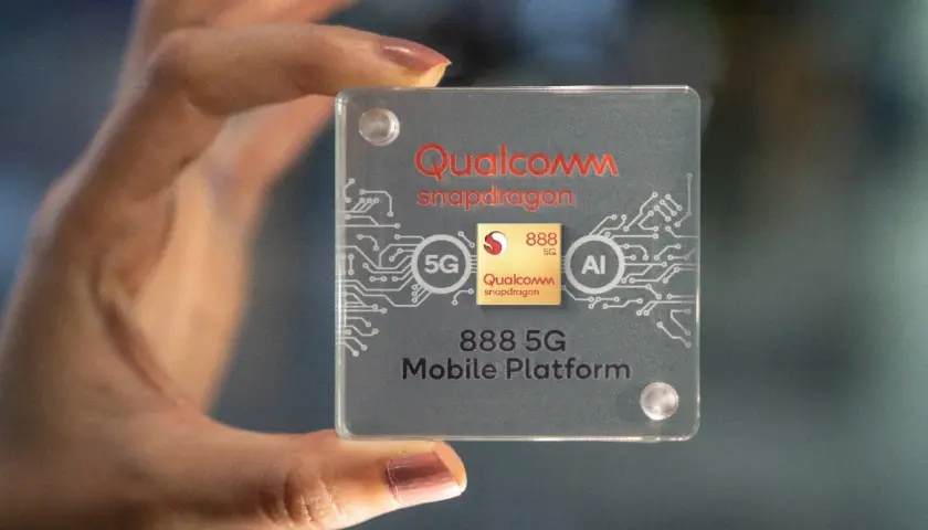 Dłoń trzyma przezroczystą płytkę z logo Qualcomm Snapdragon 888 5G Mobile Platform, symbolizującą moc i innowacje.