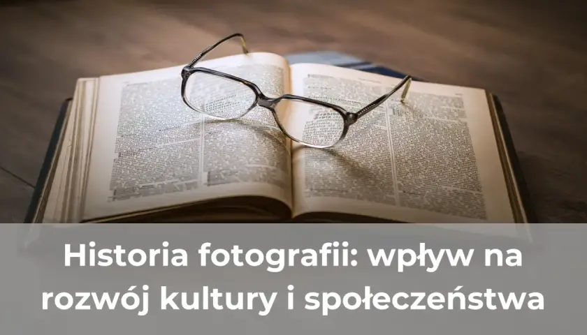Okulary spoczywają na otwartej księdze, symbolizując zgłębianie historii fotografii i jej wpływu na kulturę.
