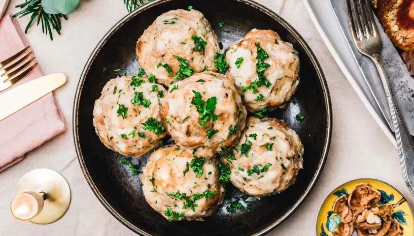 Vegane Knödel, garniert mit Petersilie, auf einem Teller. Ein köstliches veganes Knödel Rezept für ein festliches Essen.