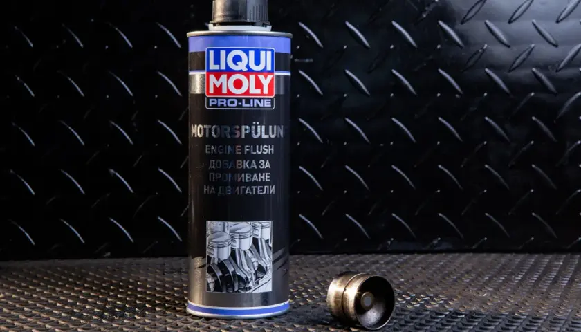Puszka Liqui Moly Engine Flush, czyli moto doktor do silnika, obok metalowego elementu.