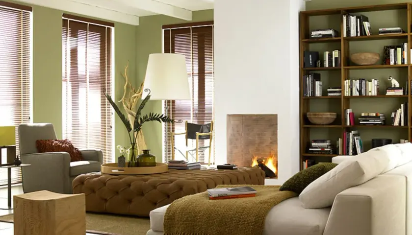 Gemütliches Wohnzimmer im kolonial stil mit Kamin, Bücherregal und bequemen Sitzmöbeln.