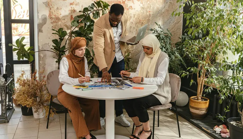 A diverse team collaborates on a project, promoting DEI through inclusive teamwork and shared learning.
