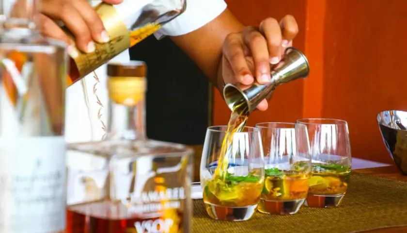 Barman nalewa likier do szklanek. W tle butelka z napisem VSOP. Zastanawiasz się, ile procent ma likier?