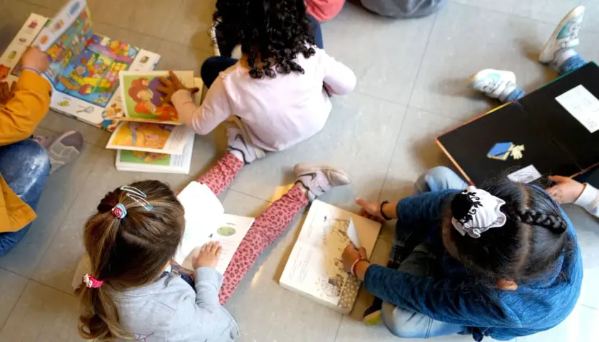 Niños aprendiendo a leer, quizás con ayuda del bono infantil Comunidad Valenciana.
