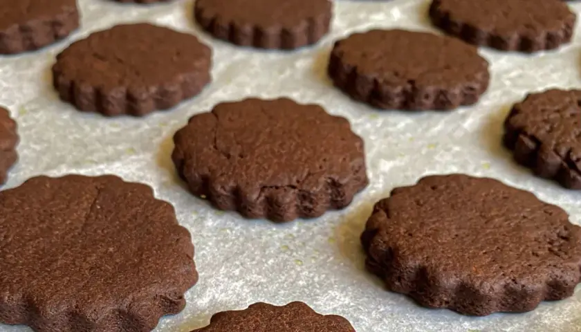 Deliziosi biscotti senza burro al cacao, con bordo ondulato, pronti per essere gustati.