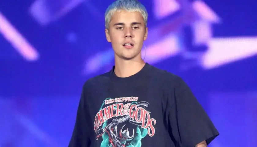 Justin Bieber z niebieskimi włosami na scenie, w koszulce z napisem "Hammer of the Gods", jak w tekście "Beauty and a Beat".