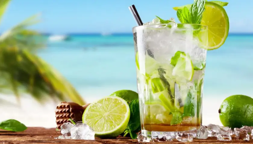 Orzeźwiający przepis na mojito z Bacardi na plaży. Lody, limonki i mięta w szklance.