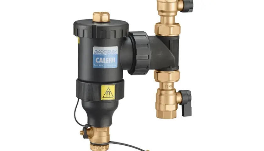 Urządzenie do czyszczenia filtra magnetycznego Caleffi DIRTMA G. Złote zawory i czarny korpus.