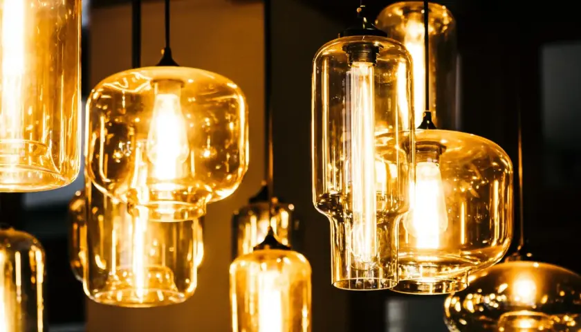Jak czyścić szklany klosz lampy? Kilka wiszących lamp z bursztynowymi kloszami i widocznymi żarówkami.