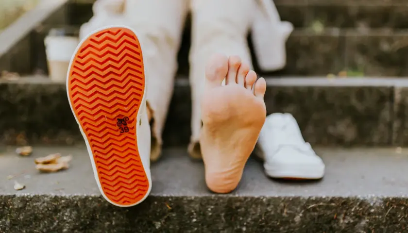 Naga stopa obok buta. **Barefoot co to znaczy**? To wolność i kontakt z podłożem, jak na schodach.
