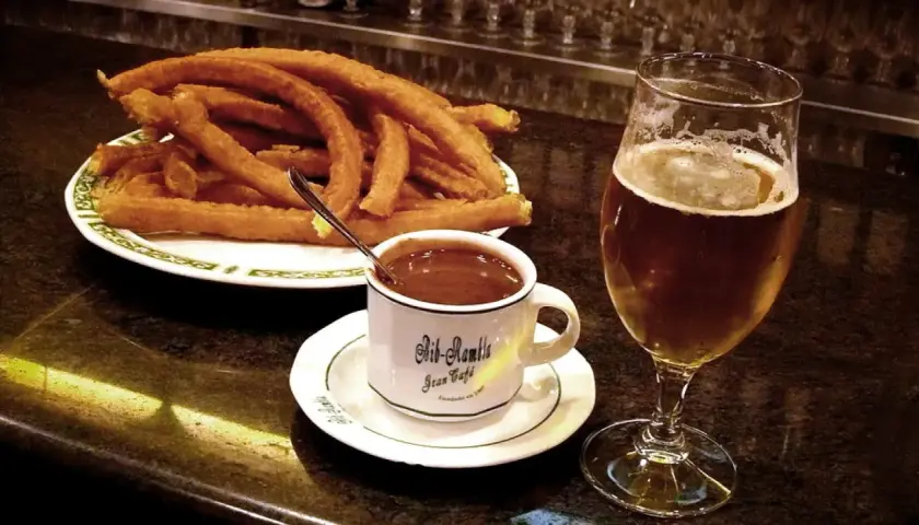 Churros con chocolate y una cerveza, cosas típicas de España.