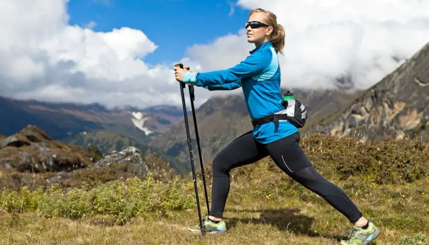 Kobieta ćwiczy nordic walking w górach. Po miesiącu regularnych treningów widać pierwsze efekty: lepszą kondycję i smuklejszą sylwetkę.