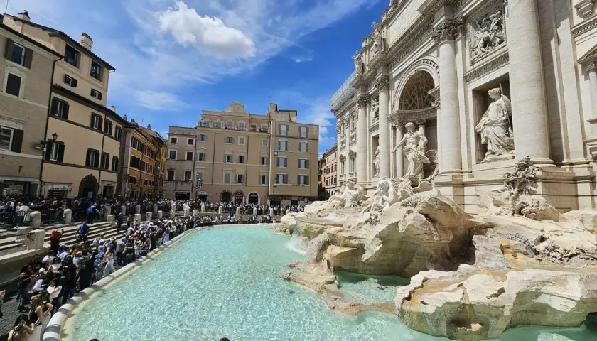 Fontana di Trevi, una delle più celebri fontane di Roma, con una folla di turisti che ammirano la sua maestosità.