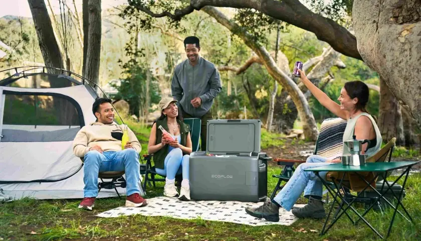 Amis profitant d'un camping chez l'habitant en France, avec tente, glacière et boissons.