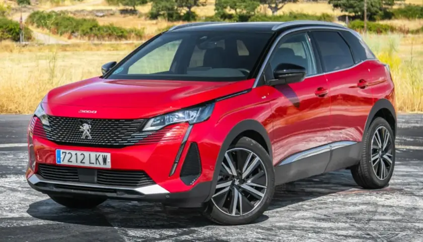 Opiniones del motor Peugeot 3008 1.5 HDI 130 CV: SUV rojo brillante aparcado en un camino rural con vegetación seca al fondo.