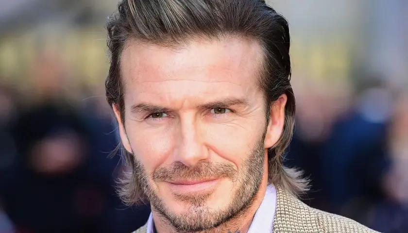 David Beckham con su icónica media melena, un estilo que inspira a muchos hombres sobre como dejarse media melena hombre.