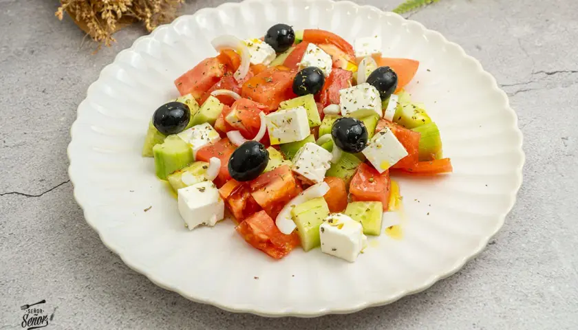 Ensalada griega con sus frescos ingredientes: tomate, pepino, cebolla, aceitunas negras y queso feta.