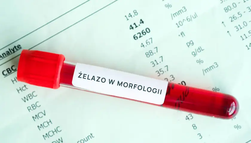Czerwona probówka z krwią na tle wyników badań laboratoryjnych. Etykieta na probówce informuje o badaniu "ŻELAZO W MORFOLOGII".