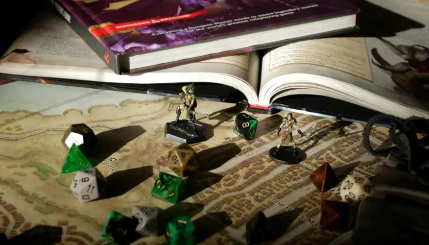 Księga Dungeons & Dragons, kostki do gry i figurki na mapie. Przygotowania do sesji dnd.
