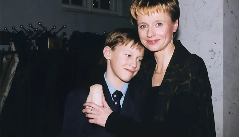 Uśmiechnięty Mateusz Matczak, syn Pieńkowskiej, w garniturze, przytulony do mamy.