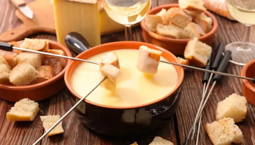 Fonduta cremosa con pane croccante e formaggio svizzero. Gli ingredienti perfetti per una serata conviviale.