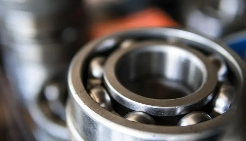 Zbliżenie na metalowe łożysko kulkowe z widocznymi kulkami.