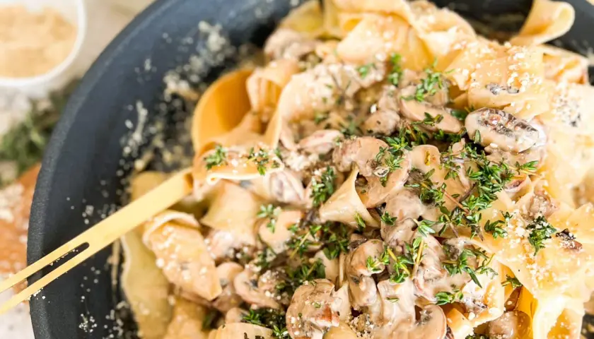 Cremige Pasta mit Pilzen und frischem Thymian, garniert mit Parmesan. Ein köstliches Gericht, das Lust auf mehr macht.