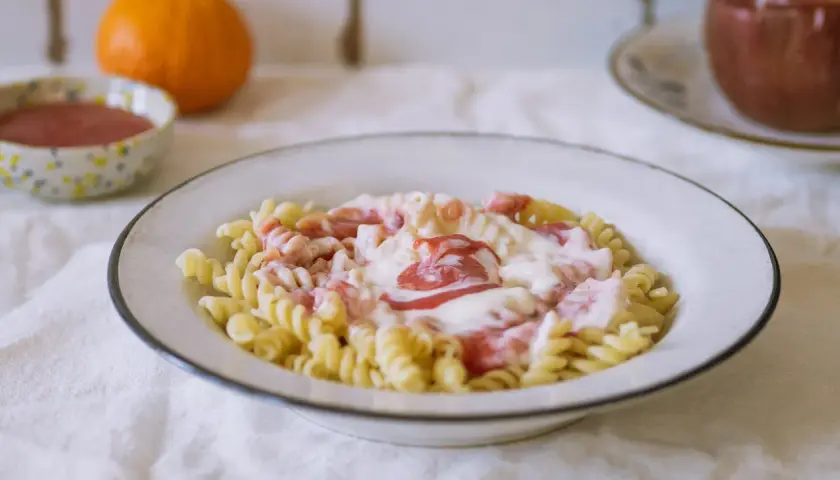 Fusilli z kremowym sosem i kawałkami owoców. Pyszny makaron na słodko, idealny na deser.