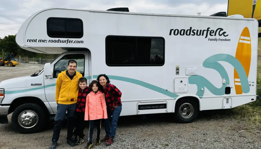 Famille souriante devant un camping-car Roadsurfer prêt pour un road trip Canada. L'aventure commence !