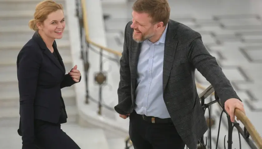 Adrian Zandberg i jego żona rozmawiają na schodach.