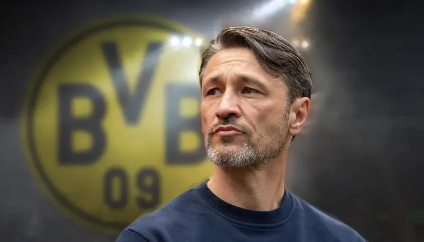 Twarz trenera Borussii Dortmund, z charakterystycznym logo klubu w tle.
