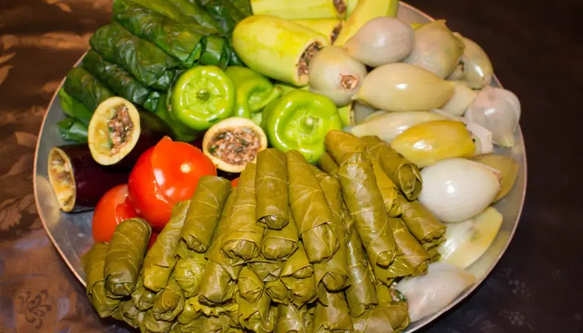 Stor bricka med fyllda vinblad, gröna paprikor, tomater, aubergine, zucchini och lök. Ett härligt dolma recept!