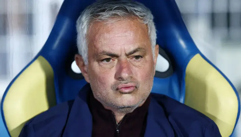 Jose Mourinho, były trener Realu Madryt, siedzi na ławce rezerwowych, zamyślony.