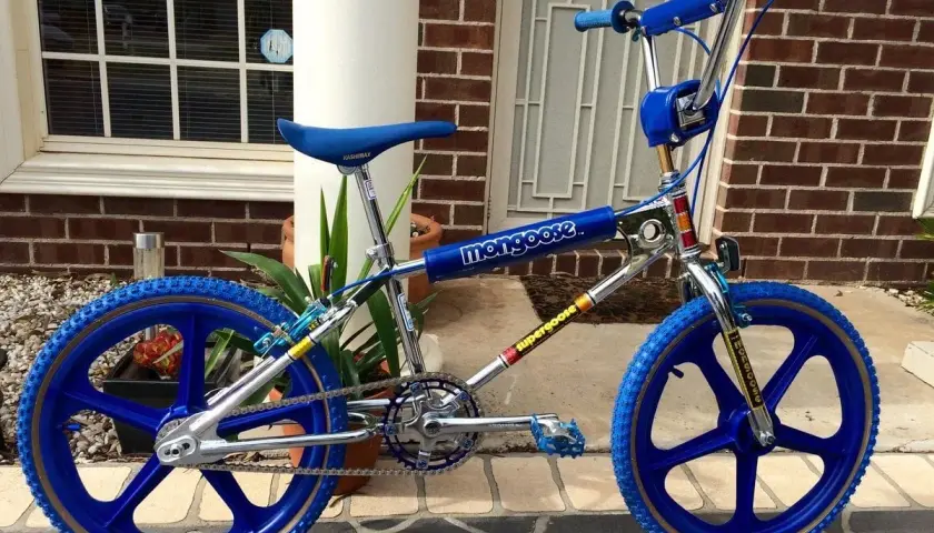 A blue Mongoose Supergoose BMX bike, a classic from the 1980s bicycle brands, with chrome accents and blue mag wheels.