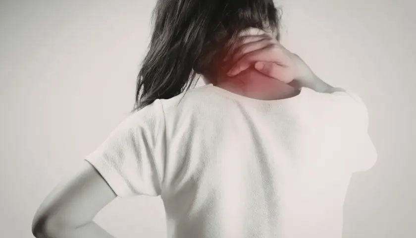 Dolor en el trapecio musculo. Una persona se sujeta el cuello, con una zona enrojecida indicando molestia.