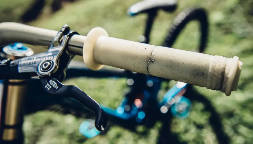 Jasne, oto opis:

Gripy do MTB – jasne, z wyraźną fakturą, idealne do pewnego chwytu. Widoczna dźwignia hamulca.