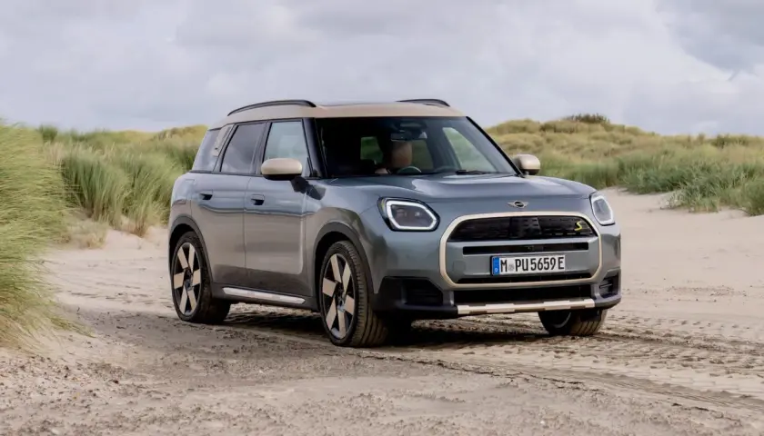Grå Mini Countryman på sandig väg vid en strand. En spännande mini countryman test i en unik miljö.