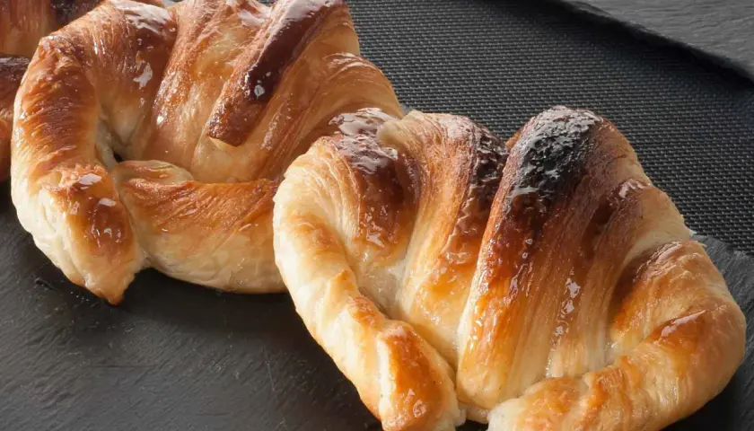 Deliciosos croissants dorados y brillantes, perfectos para aprender como hacer croissant casero.