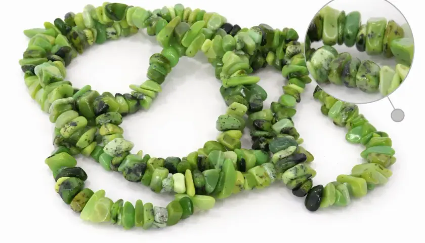 Grüne Chrysopras-Steine, die für ihre beruhigende Wirkung bekannt sind, bilden eine Kette.
