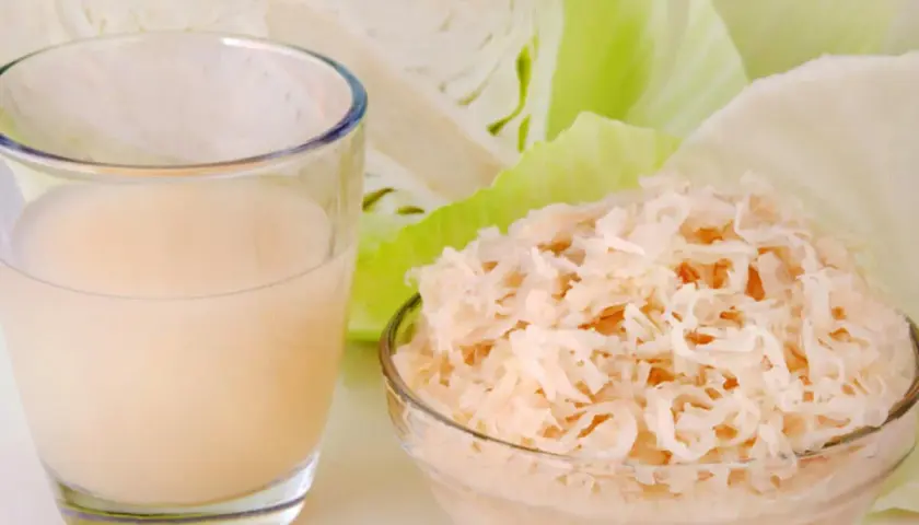 Glas mit Sauerkrautsaft, Schüssel mit Sauerkraut und Weißkohl. Ideal für eine Sauerkrautsaft Kur. Anleitung hier.